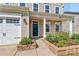 Welcoming front entrance with a covered porch, landscaped garden bed, and a convenient two-car garage at 7079 Waterwheel Sw St, Concord, NC 28025