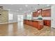 Spacious kitchen with granite countertops, stainless steel appliances, and hardwood flooring at 7079 Waterwheel Sw St, Concord, NC 28025