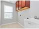 Laundry room featuring tile flooring, storage cabinets, and sink with faucet at 7079 Waterwheel Sw St, Concord, NC 28025