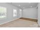 Bright and airy living room with natural light, fresh paint, and neutral carpeting at 7079 Waterwheel Sw St, Concord, NC 28025