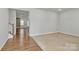 Open-concept living space with wood-look floors flowing into a carpeted area, offering a versatile layout at 7079 Waterwheel Sw St, Concord, NC 28025