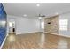 Spacious living room with hardwood floors, a stone accent wall, and an open layout at 7079 Waterwheel Sw St, Concord, NC 28025
