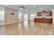 Open-concept living area featuring hardwood floors, stone accent wall, and modern kitchen island at 7079 Waterwheel Sw St, Concord, NC 28025