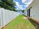 Fenced backyard with green grass, a small patio, and a sliding door at 7315 Fig Ln, Charlotte, NC 28215