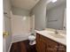Standard bathroom with a shower-tub combo, wooden vanity, gray walls, and wood-look flooring at 7315 Fig Ln, Charlotte, NC 28215