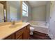 Bathroom featuring a soaking tub, single vanity, and wood-look flooring at 7315 Fig Ln, Charlotte, NC 28215