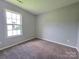 Bedroom with neutral carpet, light gray walls, and a window providing natural light at 7315 Fig Ln, Charlotte, NC 28215