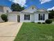 Charming single-story home with black shutters, lush lawn and a driveway leading to a one car garage at 7315 Fig Ln, Charlotte, NC 28215