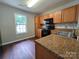 Kitchen featuring wood cabinets, granite counters, and stainless steel sink at 7315 Fig Ln, Charlotte, NC 28215