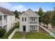 Two-story home with double balconies and a white picket fence enclosing the lush, green front lawn at 9704 Grier Springs Ln, Charlotte, NC 28213