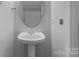 Neat half-bathroom features a stylish pedestal sink and modern fixtures at 9704 Grier Springs Ln, Charlotte, NC 28213