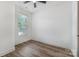 Bright bedroom with wood-look floors, ceiling fan, and natural light from a large window at 101 Bryan St, Kannapolis, NC 28083