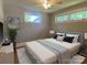 Bright bedroom featuring hardwood floors, windows, ceiling fan, and a stylish bed with a blue frame and patterned comforter at 1017 Andover Rd, Charlotte, NC 28211