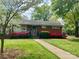 Charming brick home featuring a well-manicured front lawn, blooming azaleas, and mature trees at 1017 Andover Rd, Charlotte, NC 28211
