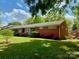 Charming brick home featuring a well-manicured front lawn, blooming azaleas, and mature trees at 1017 Andover Rd, Charlotte, NC 28211