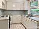 Traditional kitchen with white cabinets, marble countertops, and black and white patterned floors at 1017 Andover Rd, Charlotte, NC 28211