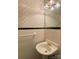 Compact powder room featuring textured wallpaper, a decorative mirror, and a stylish sink with a gold faucet at 1017 Andover Rd, Charlotte, NC 28211