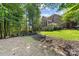 Expansive backyard featuring a patio, lush landscaping, and an attached screened-in back porch at 10320 Lemington Dr, Mint Hill, NC 28227