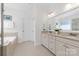 Elegant bathroom features dual sink vanities, soaking tub, and neutral tile throughout at 10320 Lemington Dr, Mint Hill, NC 28227