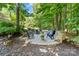 Relaxing outdoor stone patio and seating area surrounded by lush trees and landscaping at 10320 Lemington Dr, Mint Hill, NC 28227