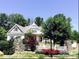 Charming two-story home with landscaped front yard, stone accents and white picket fence at 104 Bunker Way, Mooresville, NC 28117