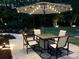 Cozy outdoor patio with table, chairs, umbrella, and ambient lighting at 104 Bunker Way, Mooresville, NC 28117