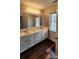 Bathroom with a double sink vanity, stylish mosaic tiles, and hardwood floors at 10607 Old Bridge Ln, Charlotte, NC 28269