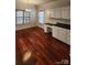 Bright kitchen area with hardwood floors, two windows, and white cabinets at 10607 Old Bridge Ln, Charlotte, NC 28269