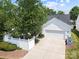 Aerial view of home with a white exterior, two car garage, fenced yard, and mature trees at 1103 Phar Lap Dr, Indian Trail, NC 28079