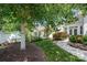 Landscaped backyard featuring a grassy area, walkway, mature tree, and white picket fence at 1103 Phar Lap Dr, Indian Trail, NC 28079