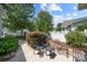 Outdoor patio seating area surrounded by lush landscaping and a white picket fence at 1103 Phar Lap Dr, Indian Trail, NC 28079