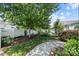 Well-maintained backyard with a lush lawn, landscaping, and white picket fence at 1103 Phar Lap Dr, Indian Trail, NC 28079