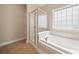 Bathroom featuring a soaking tub, glass shower and privacy window at 1103 Phar Lap Dr, Indian Trail, NC 28079