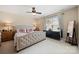 Cozy bedroom featuring a tufted headboard, ceiling fan, and natural light at 1103 Phar Lap Dr, Indian Trail, NC 28079