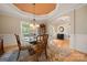 Dining room featuring a chandelier, glass top table and view into the front entry at 1103 Phar Lap Dr, Indian Trail, NC 28079