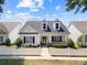 Charming two-story home features a white picket fence and inviting front porch with comfortable seating and landscaping at 1103 Phar Lap Dr, Indian Trail, NC 28079