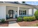 Inviting front porch with rocking chairs and bench seating, complemented by a black front door and landscaped yard at 1103 Phar Lap Dr, Indian Trail, NC 28079