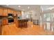 A spacious kitchen features an island with barstool seating, hardwood floors, and stainless steel appliances at 1103 Phar Lap Dr, Indian Trail, NC 28079