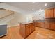 Hardwood kitchen features an island, stainless steel appliances, plenty of counter space, and stairs leading to the second floor at 1103 Phar Lap Dr, Indian Trail, NC 28079