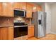 Updated kitchen showcases stainless steel appliances, granite countertops, a tiled backsplash, and wood cabinetry at 1103 Phar Lap Dr, Indian Trail, NC 28079