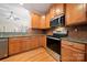 Well-appointed kitchen features granite counters, stainless steel appliances, wood cabinets, and tiled backsplash, modern and functional at 1103 Phar Lap Dr, Indian Trail, NC 28079