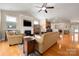 Bright living room with fireplace, tv, and views into the kitchen and dining areas at 1103 Phar Lap Dr, Indian Trail, NC 28079