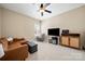 Cozy living room featuring a brown sofa, accent chair, ottoman and entertainment center at 1103 Phar Lap Dr, Indian Trail, NC 28079