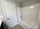 A shower-tub combo in a full bathroom with white trim and vinyl flooring at 11109 Pond Valley Ct, Charlotte, NC 28269