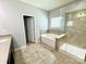 Bright bathroom with a soaking tub, shower, and neutral tile at 11109 Pond Valley Ct, Charlotte, NC 28269