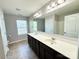 Bright bathroom with double sink vanity, large mirror, and vinyl flooring at 11109 Pond Valley Ct, Charlotte, NC 28269