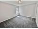 Neutral bedroom with a single window that allows natural light onto the gray carpeted floors at 11109 Pond Valley Ct, Charlotte, NC 28269