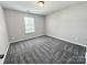 Neutral bedroom with a single window that allows natural light onto the gray carpeted floors at 11109 Pond Valley Ct, Charlotte, NC 28269