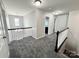Spacious hallway with gray carpet and neutral walls, leading to several rooms and a chandelier at 11109 Pond Valley Ct, Charlotte, NC 28269
