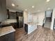 Kitchen with granite island, stainless steel appliances, and adjacent stairs at 11109 Pond Valley Ct, Charlotte, NC 28269